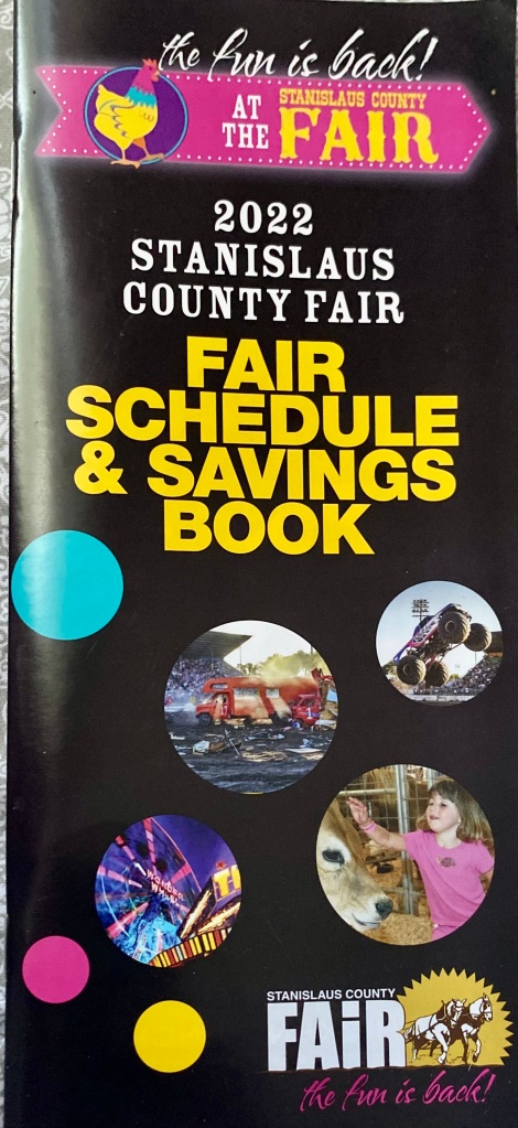 Black pamphlet decorated with bubble-shaped photos of various aspects of the fair. Yellow and white lettering declares that this is the schedule and savings book.